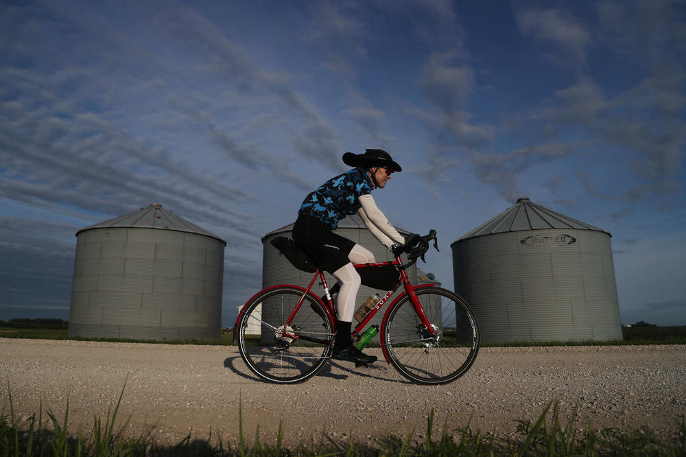 A rider passes by a set of silos along the optional gravel loop Tuesday, July 26, on his way from Pocahontas to Havelock, Iowa, on Day 3 of RAGBRAI.