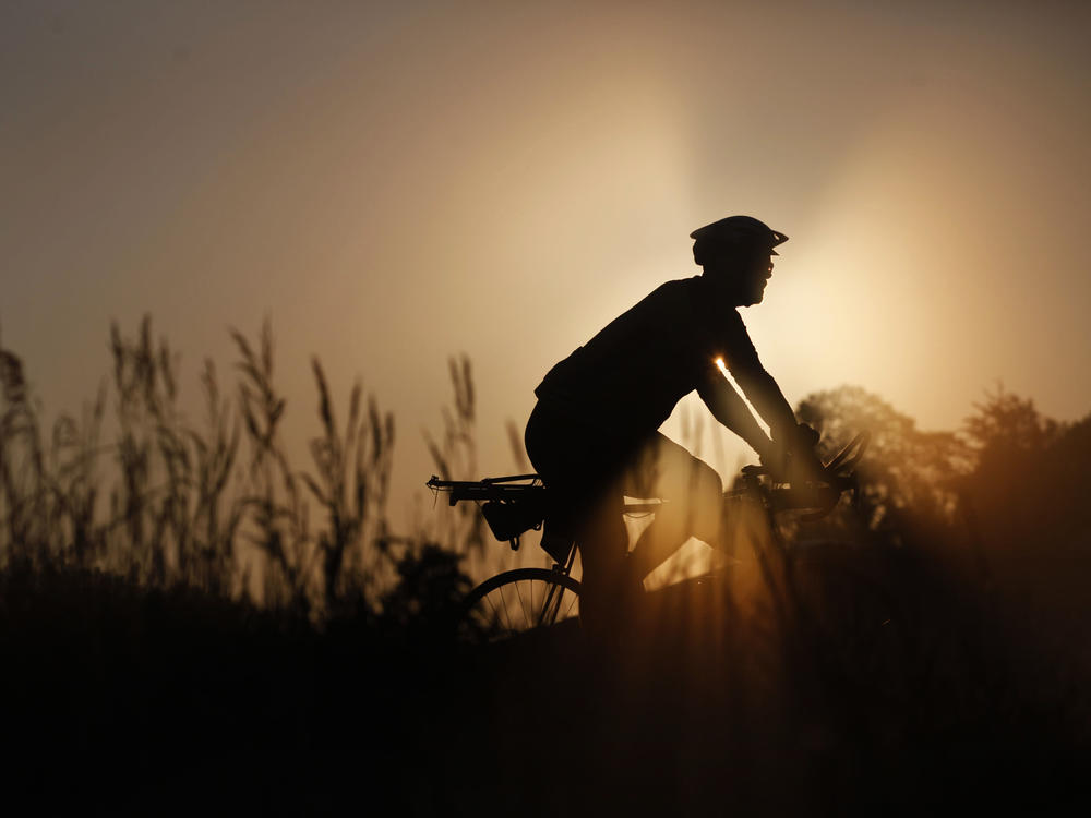 A rider makes their way along RAGBRAI's route on a foggy morning Wednesday, July 28, outside of Emmetsburg, Iowa, on Day 4 of the annual recreational bike ride across the state of Iowa.