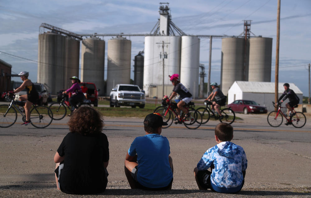 A group of children watch as riders make their way into town Tuesday, July 26, in Rolfe, Iowa, on Day 3 of RAGBRAI.