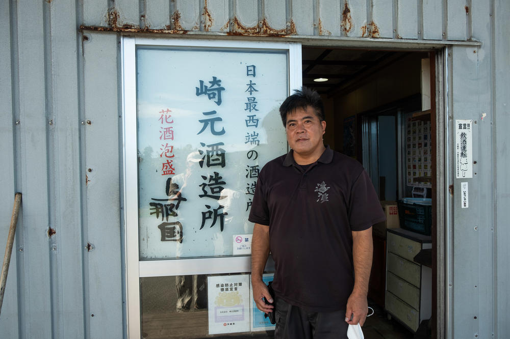 Toshio Sakimoto, head of Yonaguni's town assembly, stands outside his business, where he distills Awamori, a 120-proof rice liquor made on Yonaguni and Okinawa.