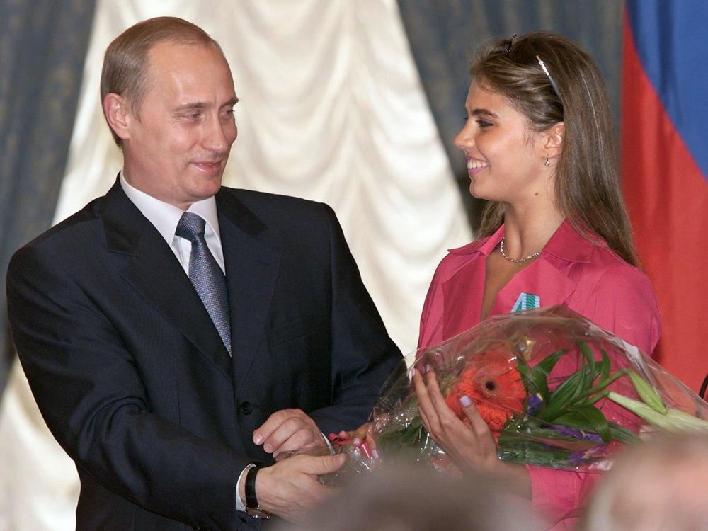 Russian President Vladimir Putin hands flowers to Alina Kabaeva after awarding her with an Order of Friendship during a ceremony at the Kremlin in June 2001.