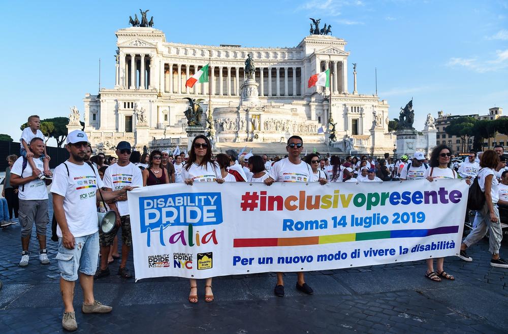 People from Italian disability organizations hold a banner reading 
