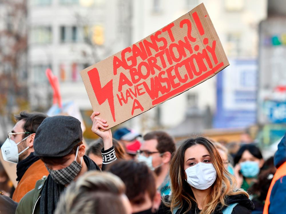 A demonstrator in Berlin in 2020 holds up a placard reading 