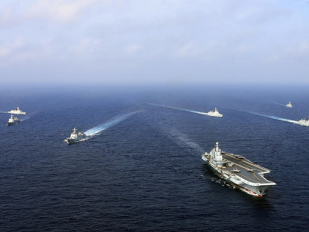 An April 2018 photo provided by the Chinese government shows the country's first aircraft carrier, the Liaoning (front), steaming with other ships during a drill at sea.