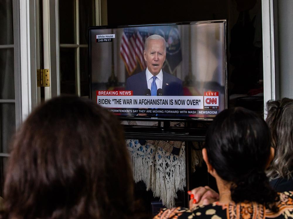 A group of military families and veterans watch President Joe Biden's speech announcing that all troops are out of Afghanistan, on Aug. 31, 2021 in Long Beach California.