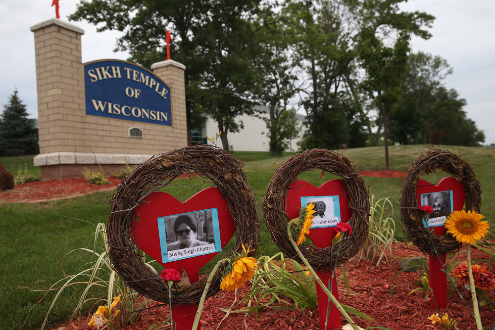 Photos of the victims of the shooting at the Sikh Temple of Wisconsin sit in front of the temple during a service held to mark the one-year anniversary of the shooting rampage that killed six members of the temple Aug. 5, 2013, in Oak Creek, Wis. The six temple members were killed by white supremacist Michael Page, who later killed himself.