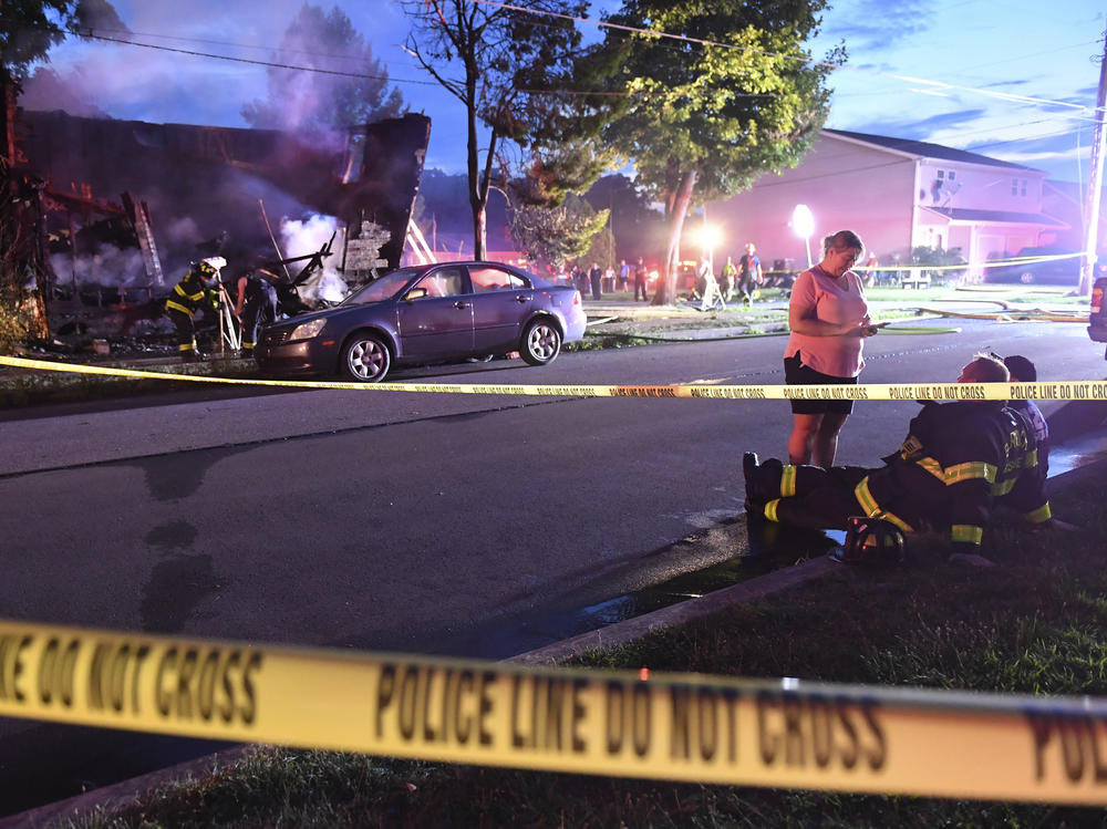 Firefighters on Friday set up lights in front of a fatal house fire in Nescopeck, Pa., that killed 10 people.