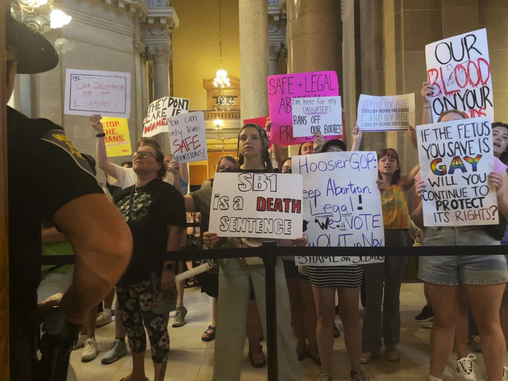 Abortion-rights protesters fill Indiana Statehouse corridors and cheer outside legislative chambers on Friday as lawmakers vote to concur on a near-total abortion ban, in Indianapolis.