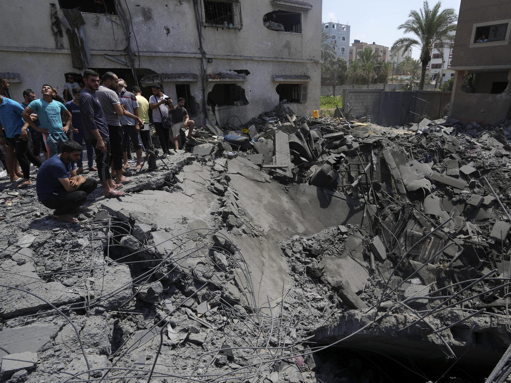 Gaza residents on Saturday inspect the rubble of a destroyed residential building hit by Israeli airstrikes.
