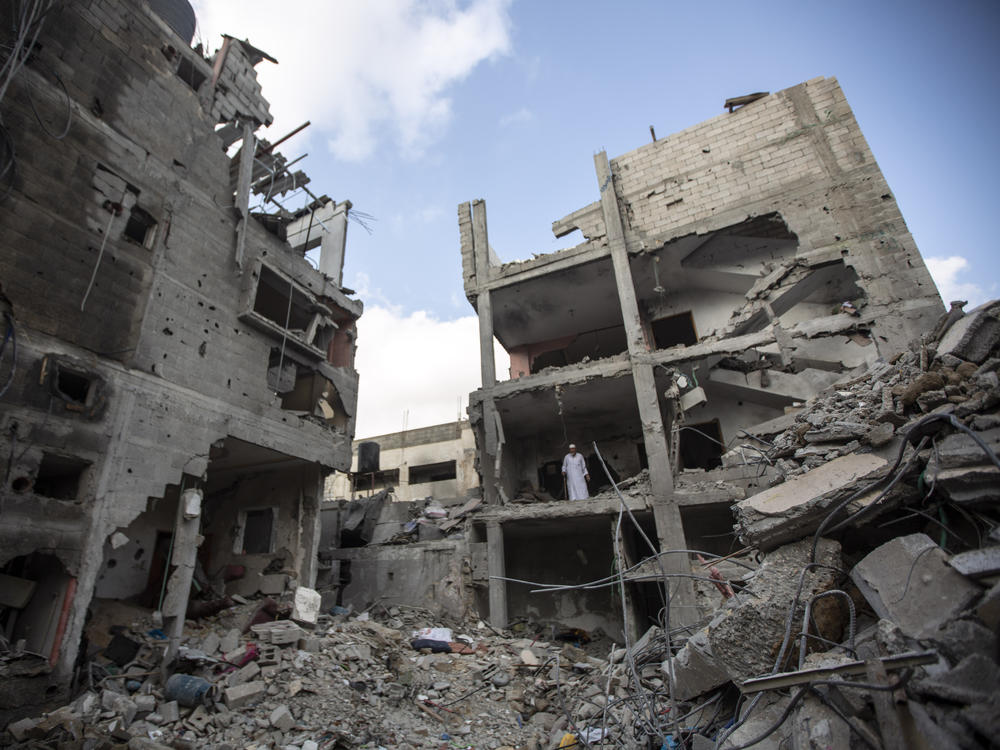 Palestinians search through the rubble of a building in which Khaled Mansour, a top Islamic Jihad militant was killed following an Israeli airstrike in Rafah, southern Gaza strip, Sunday, Aug. 7, 2022.