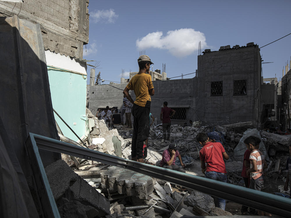 Palestinians search through the rubble of a building in which the Islamic Jihad militant Khaled Mansour was killed following an Israeli airstrike. Two other militants and five civilians were also killed in the attack.