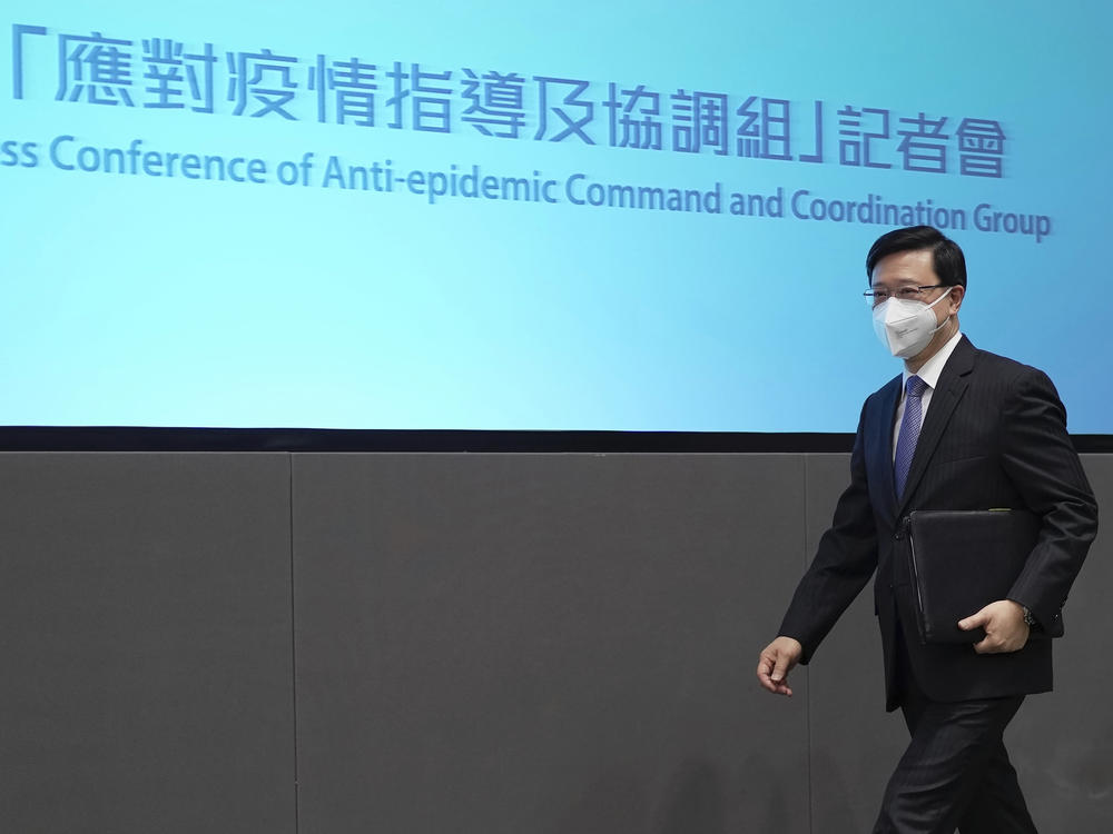 Hong Kong Chief Executive John Lee arrives for a news conference in Hong Kong, Monday, Aug. 8, 2022.