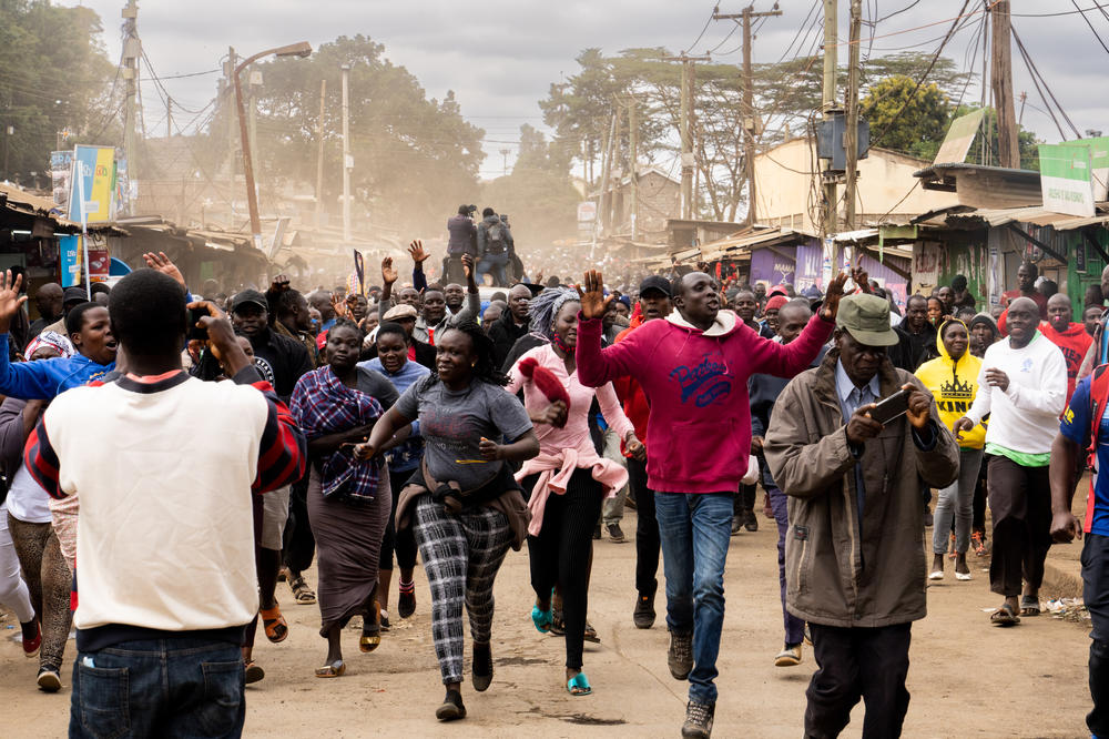 A large crowd runs ahead of a motorcade shuttling presidential candidate Raila Odinga, after he cast his votes in the Kibera slum in Nairobi.