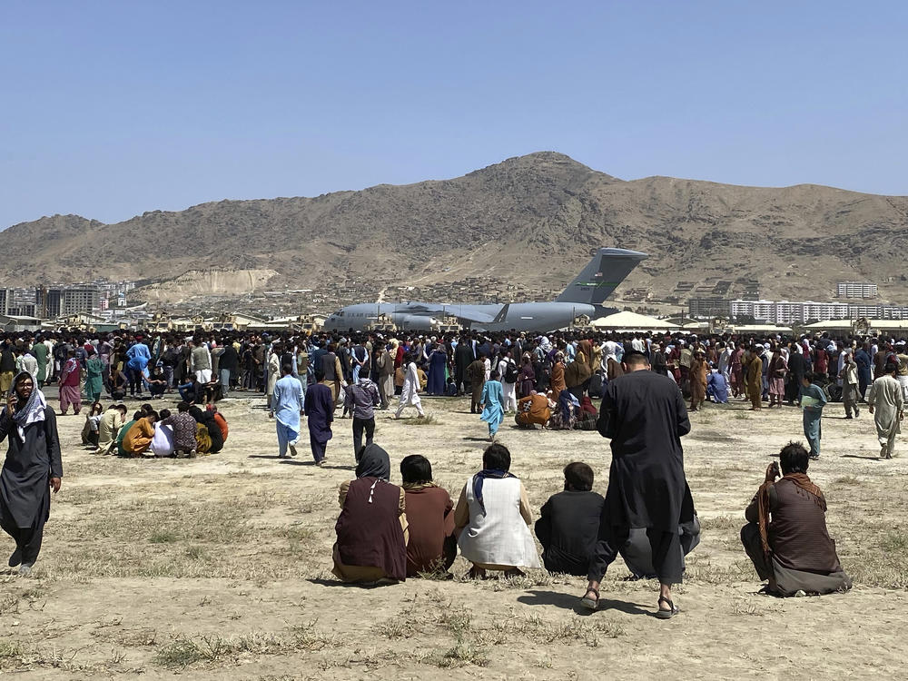 Hundreds of people gather near a U.S. Air Force C-17 transport plane at the perimeter of the international airport in Kabul, Afghanistan, on Aug. 16, 2021.