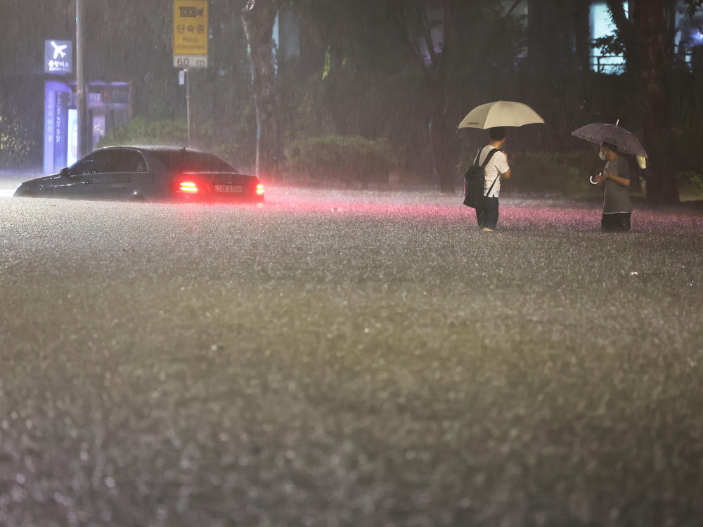 A vehicle is submerged in a flooded road in Seoul, Monday, Aug. 8, 2022.