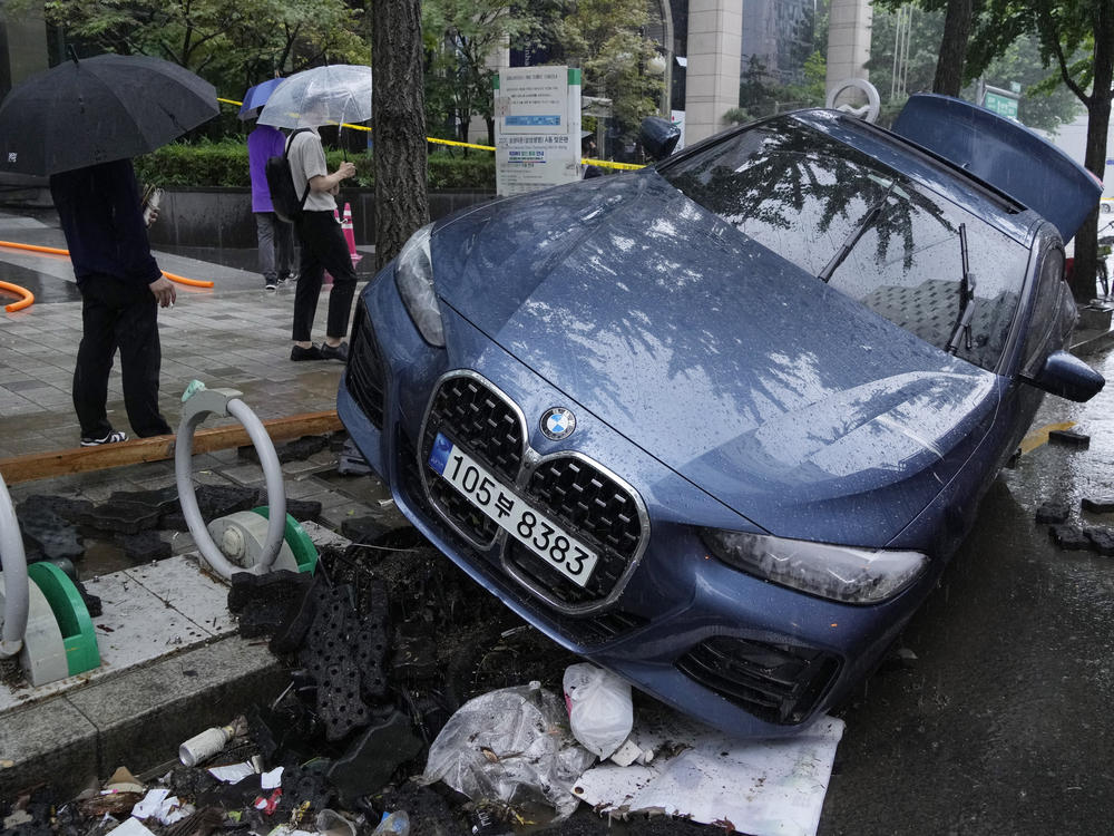 A vehicle sits damaged on a road after floating in heavy rainfall in Seoul, South Korea, Tuesday, Aug. 9, 2022.