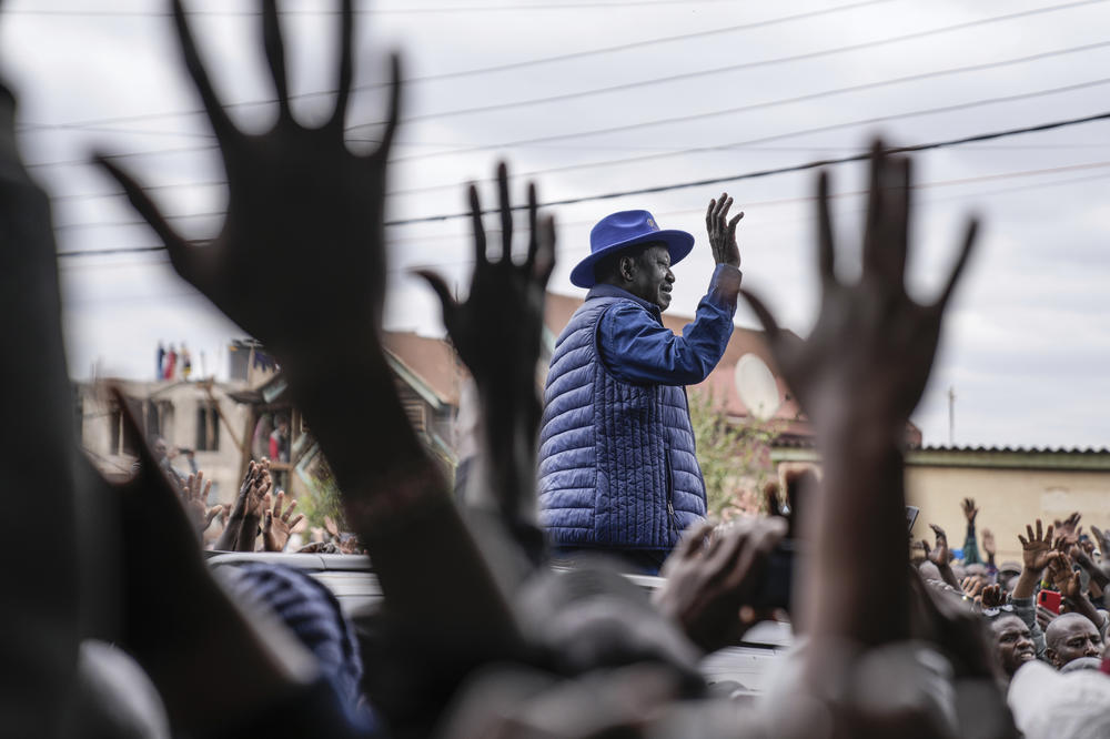 Presidential candidate Raila Odinga waves to his supporters after casting his vote at the Kibera Primary School.