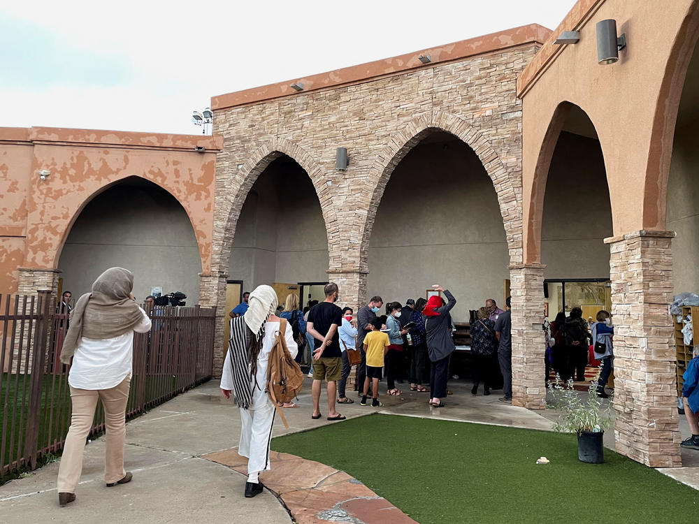 Participants in an interfaith memorial ceremony enter the New Mexico Islamic Center mosque to commemorate four murdered Muslim men, hours after police said they had arrested a prime suspect in the killings, in Albuquerque, N.M., on Tuesday.