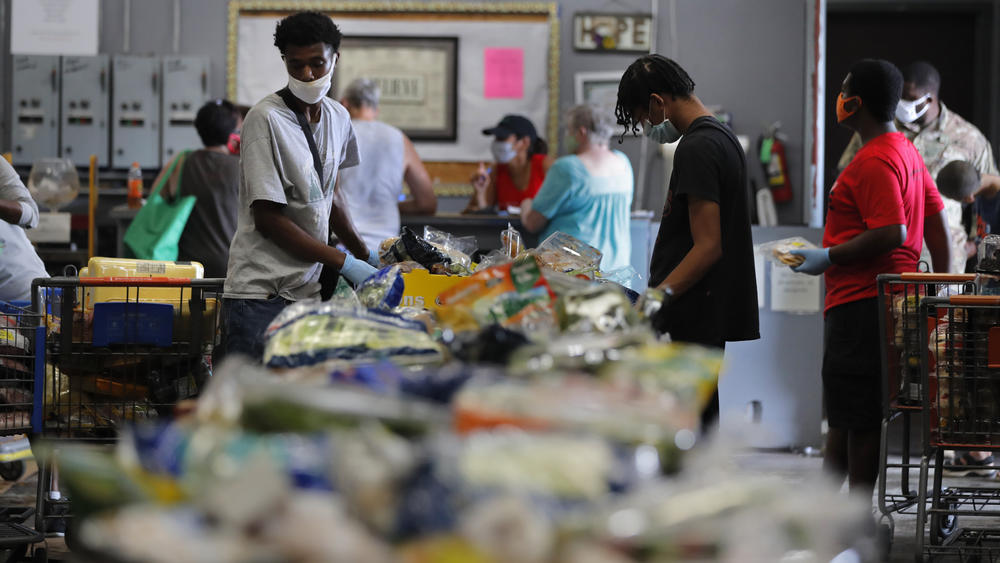 Voluteers distribute food to recipients at the Giving Hope Food Pantry during a food giveaway in New Orleans on July 21, 2020. The effort was meant to assist people who have lost income during the COVID-19 pandemic.