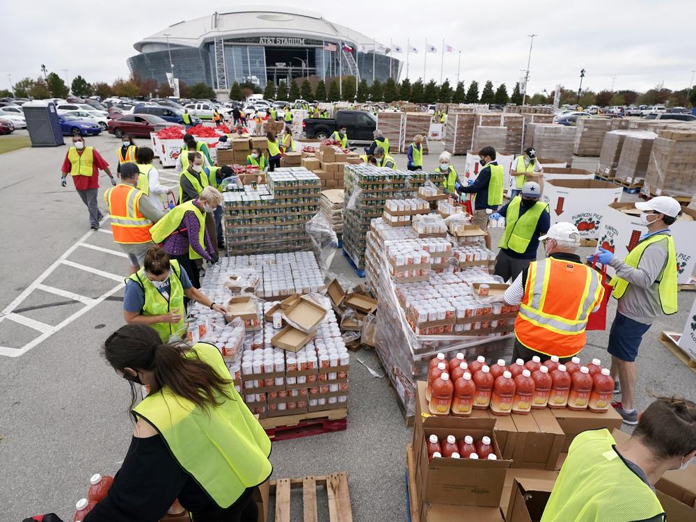 Volunteers build bags of dry goods in a parking lot outside of AT&T Stadium during a Tarrant Area Food Bank mobile pantry distribution event in Arlington, Texas, on Nov. 20, 2020.