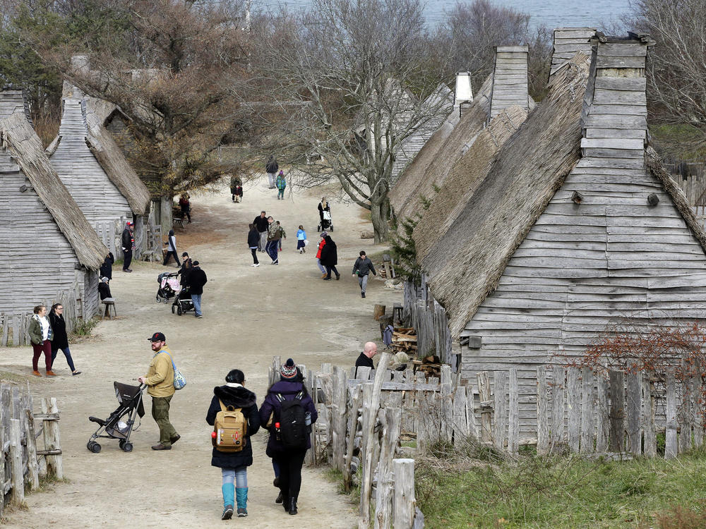 Visitors walk through the 17th-Century English Village exhibit at the Plimoth Patuxet Museums on Nov. 18, 2018, in Plymouth, Mass.