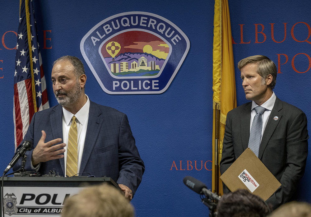 Ahmad Assed (left), president of the Islamic Center of New Mexico, speaks Tuesday at a news conference to announce the arrest of Muhammad Syed, a suspect in the recent killings of Muslim men in Albuquerque, N.M. Albuquerque Mayor Tim Keller (right) looks on.