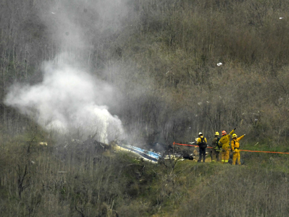 Firefighters work the scene of a helicopter crash where former NBA basketball star Kobe Bryant died in Calabasas, Calif., on Jan. 26, 2020. Bryant's widow is taking her lawsuit against the Los Angeles County Sheriff's Department and Fire Department to a federal jury seeking compensation for photos deputies shared of the remains of the NBA star, his daughter and seven others who died in the crash.