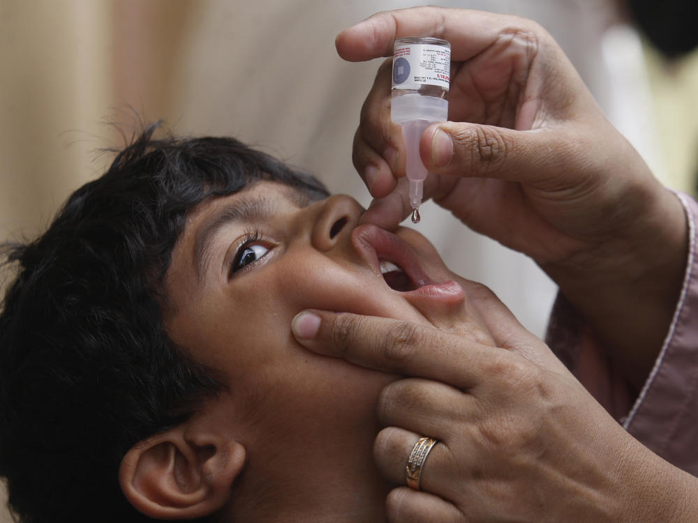A health worker gives a polio vaccine to a child in Karachi, Pakistan, on May 23. British health authorities on Wednesday said they will offer a polio booster dose to children aged 1 to 9 in London, after finding evidence the virus has been spreading in multiple regions of the capital.