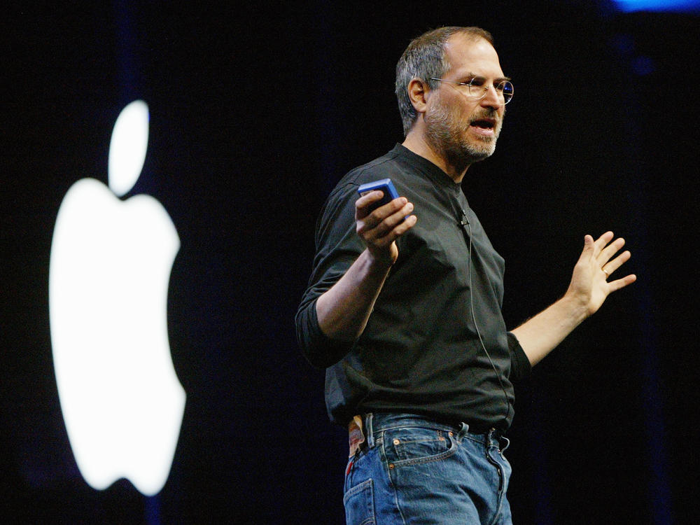 Steve Jobs, then CEO of Apple, delivers the keynote address at the Worldwide Developers Conference in 2003 in San Francisco. Jobs created a personal uniform for himself that featured a black turtleneck from Japanese designer Issey Miyake.