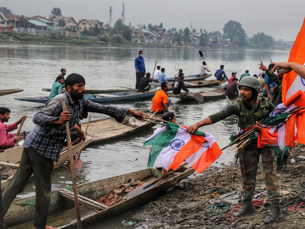 An Indian army soldier collects Indian national flags after a rally marking Indian independence in Sopore district, Baramulla, in Jammu and Kashmir, on Aug. 11.