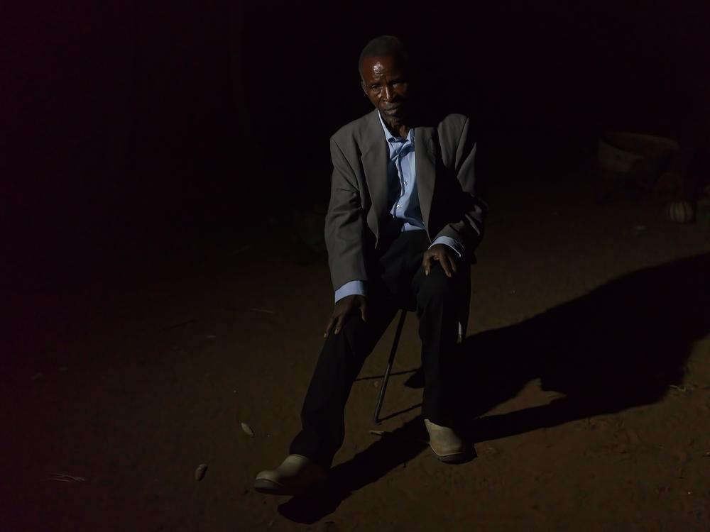 Hangani Dube, 79, sits outside his home in Cross Mabale village near Hwange National Park in north western Zimbabwe. In May, Dube was injured in an elephant attack and as result he can barely work and cannot do any of the farming activities he used to.