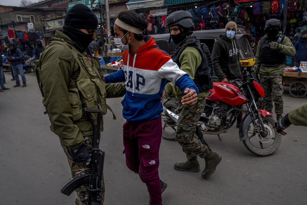 Indian paramilitary soldiers frisk a Kashmiri during a surprise check operation in Srinagar, on Jan. 18, 2022.