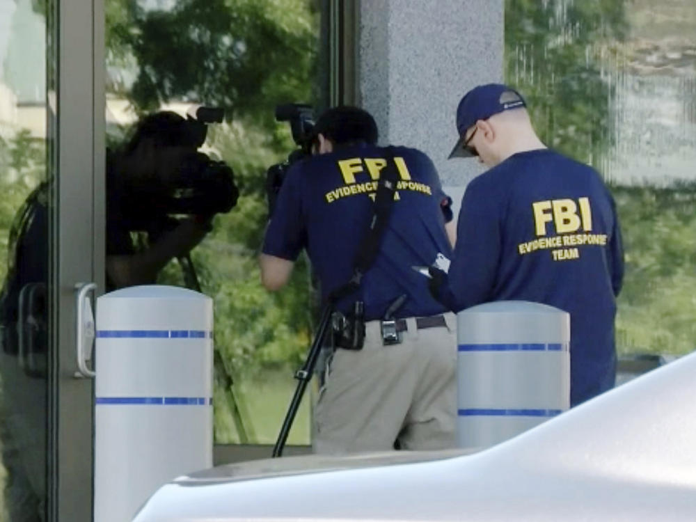 FBI agents document evidence outside a bureau field office in Kenwood, Ohio, on Aug. 11, after an armed man tried to breach the building. He fled and was later killed by law enforcement, authorities said.