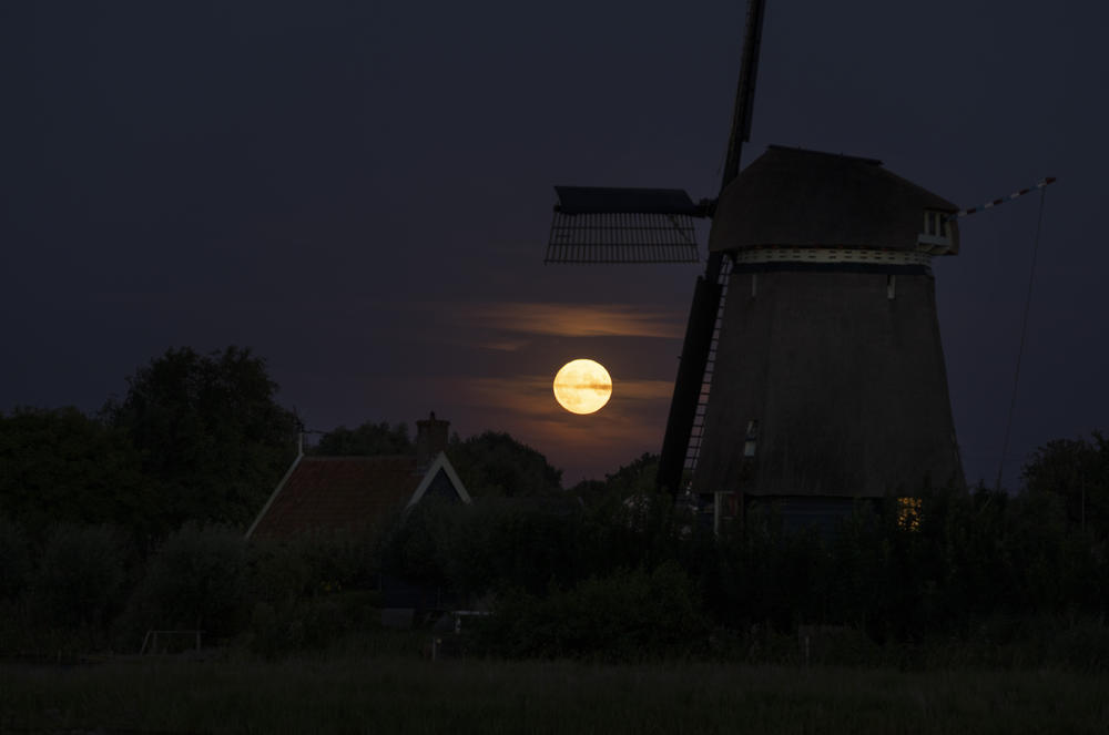 Oostzaan, Netherlands: The supermoon rises over a windmill.