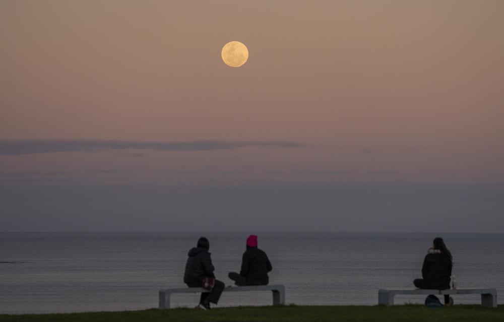 Montevideo, Uruguay: People watch as the moon rises.