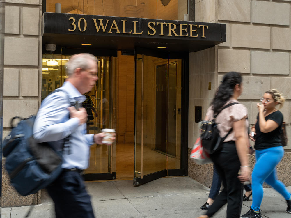 People walk outside of the New York Stock Exchange (NYSE) on July 25 in New York City. Wall Street firms including Goldman Sachs have been pushing their workers to return to work.