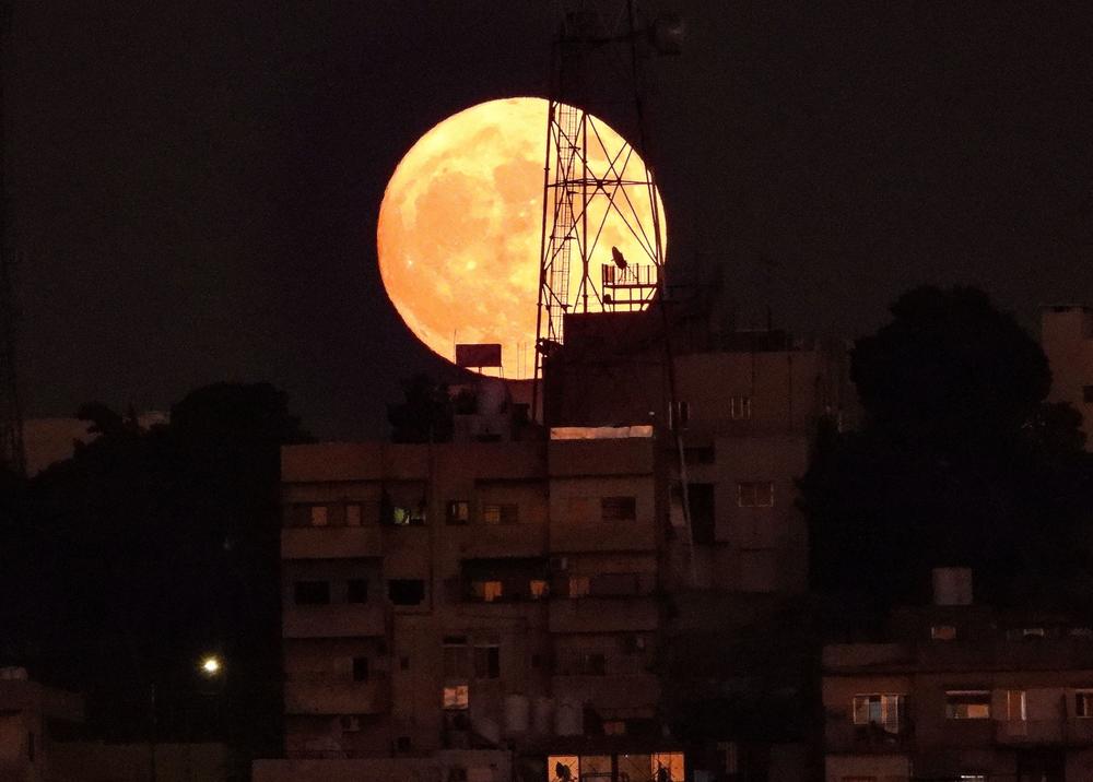 Amman, Jordan: The Sturgeon full moon rises above buildings in the Jordanian capital.