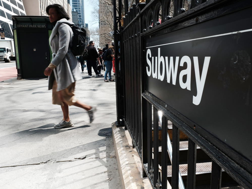 People walk by a subway stop in midtown Manhattan in New York City on April 13. Some of the city's top CEOs say they are being told by their employees that they are afraid to return to work after a recent spate of high-profile attacks.