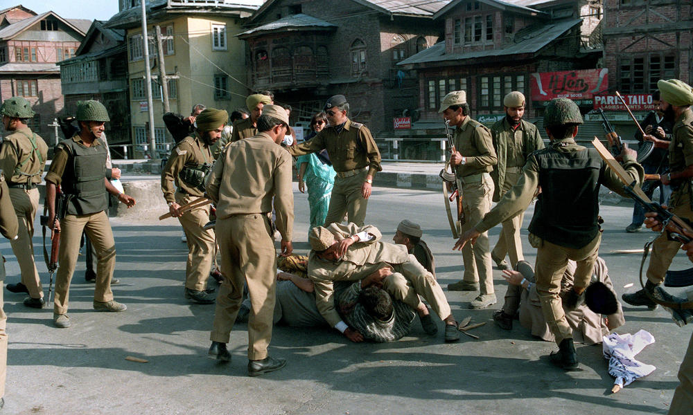 Indian security forces beat Muslim protesters at a demonstration during a curfew in Srinagar, Kashmir, in 1993. Demonstrators were protesting against the encirclement of the Hazratbal mosque by Indian soldiers.