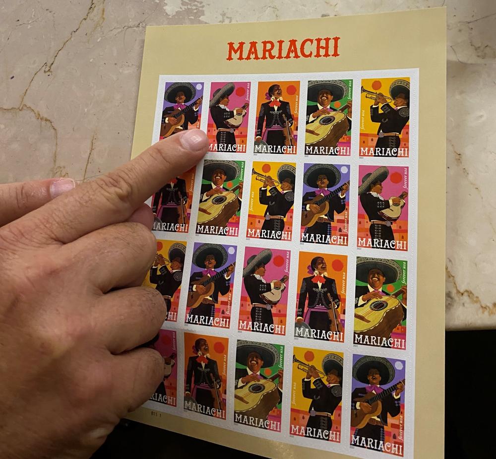López points to a set of his mariachi stamps.