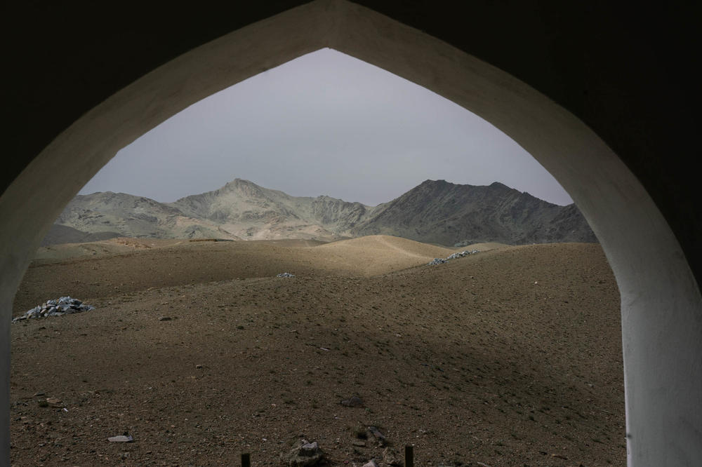 Distant mountains can be seen from an archway of a mosque in the Tangi Valley.