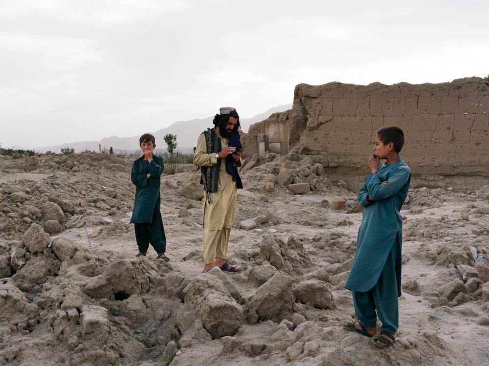 Wahadat (center) stands in the ruins of the village of Mali Khel.