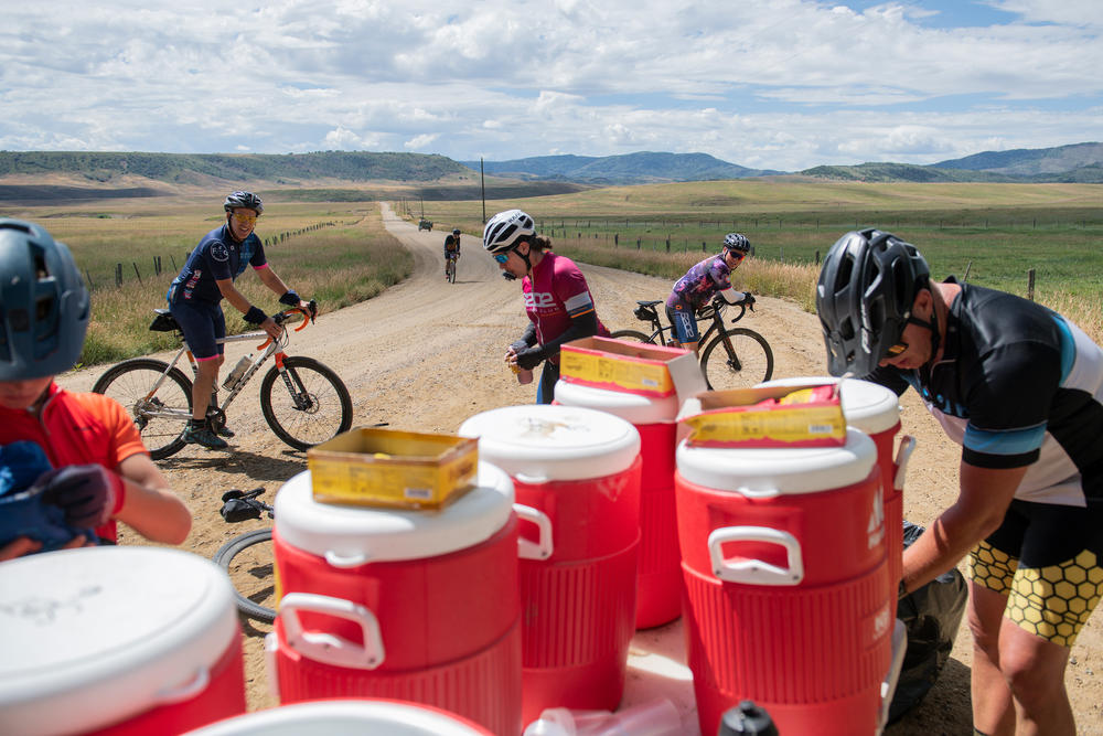 Cyclists cool down and refill at a water station.