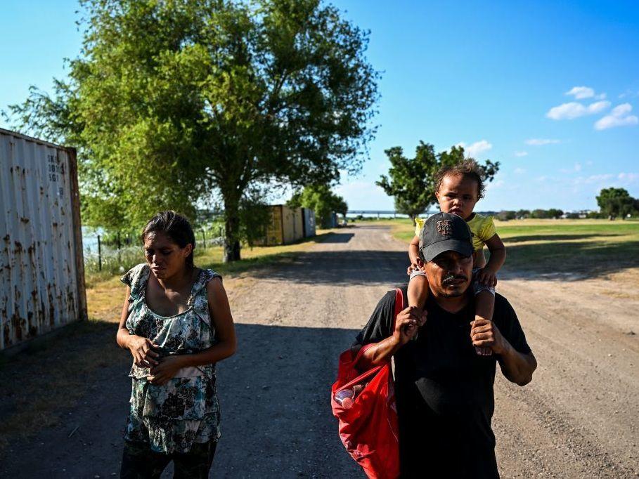 A migrant family is apprehended by U.S. Border Patrol agents and National Guard troops in Eagle Pass, Texas, near the border with Mexico on June 30, 2022.