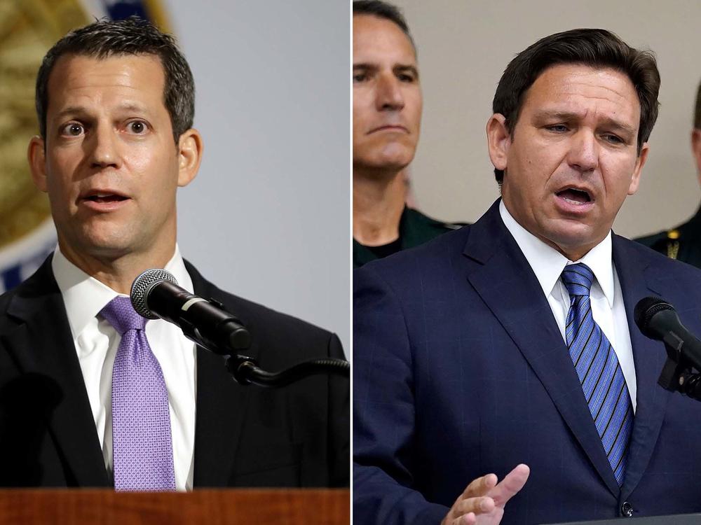 Florida Gov. Ron DeSantis, right, and Hillsborough County State Attorney Andrew Warren, left, in Tampa, Fla., after DeSantis suspended Warren. Warren vowed to fight his suspension over his promise not to enforce the state's 15-week abortion ban and support for gender transition treatments for minors.