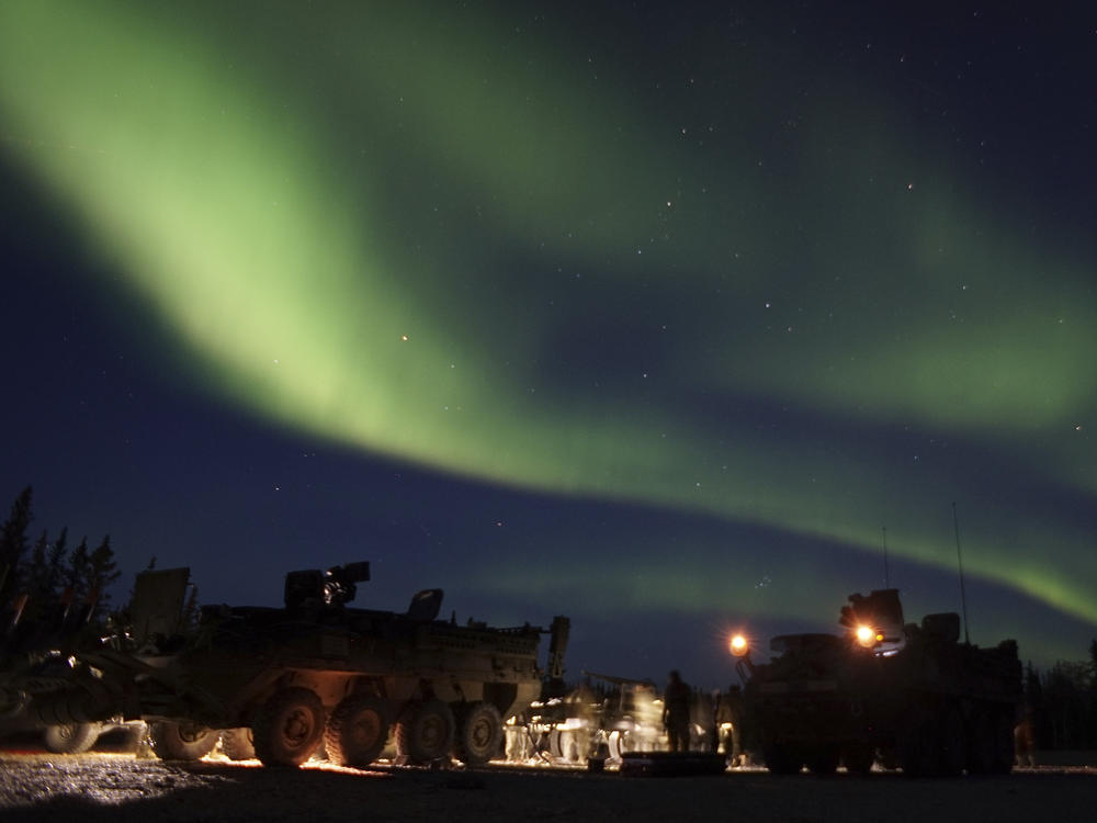 In this Sept. 15, 2017, photo provided by the U.S. Army Alaska, soldiers from Alpha Company, 70th Brigade Engineer Battalion, 1st Stryker Brigade Combat Team, 25th Infantry Division, based at Fort Wainwright, Alaska, conduct unscheduled field maintenance under the Northern Lights on a squad vehicle in preparation for platoon external evaluations at Donnelly Training Area, near Fort Greely.