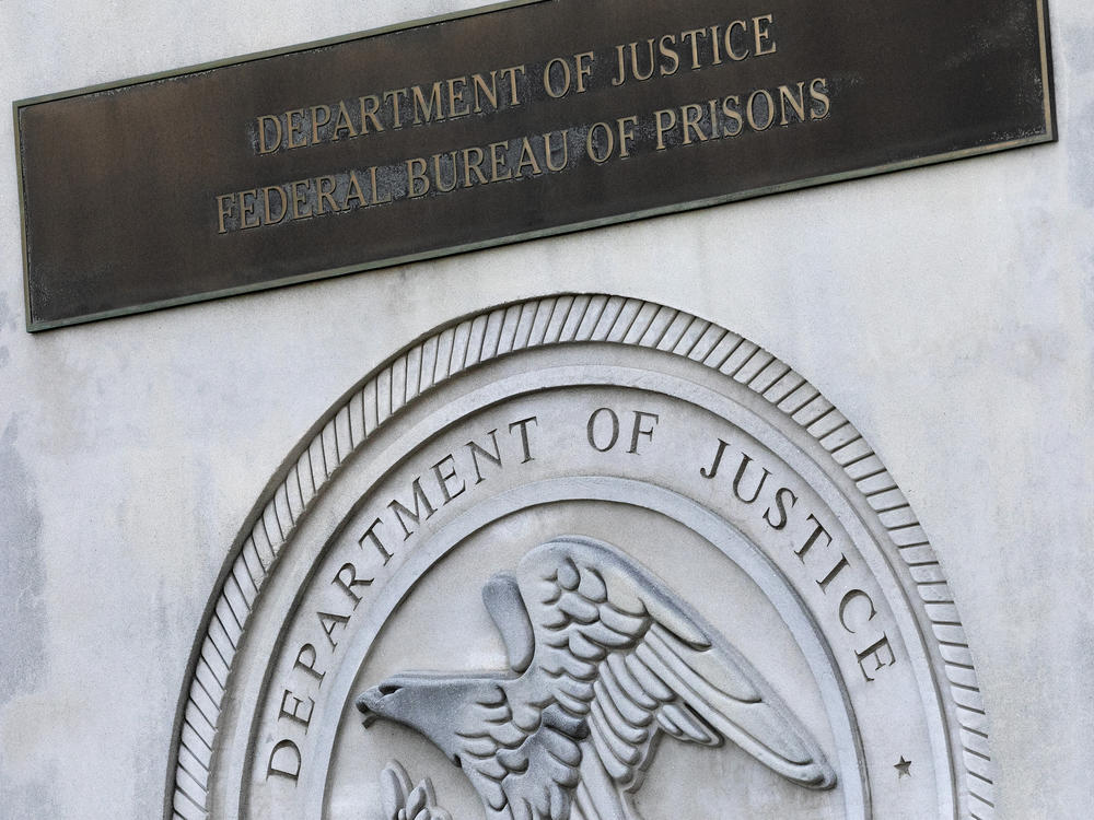 In this 2020 photo, a sign for the Department of Justice Federal Bureau of Prisons is displayed at the Metropolitan Detention Center in the Brooklyn borough of New York.