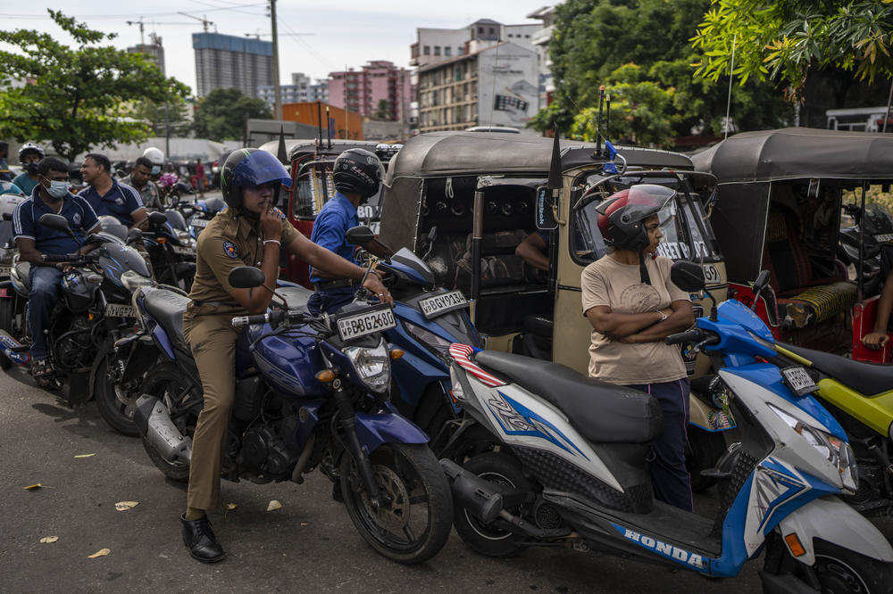 Sri Lankans wait in a queue to buy petrol at a fuel station in Colombo in July, amidst an economic downturn and a fuel shortage.