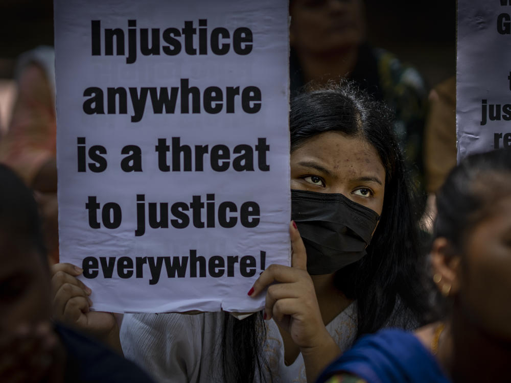 An activist holds a placard during a protest against remission of sentence by the government to convicts of a gang rape, in New Delhi, India, Thursday, Aug. 18, 2022.