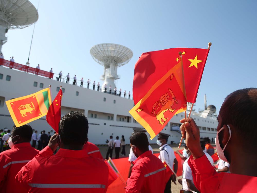 People welcoming China's ship Yuan Wang 5 wave Chinese and Sri Lankan flags at Sri Lanka's Hambantota International Port in Sri Lanka, Aug. 16.